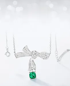 Detail view of S925 silver bow necklace with cushion cut emerald and zircon pave