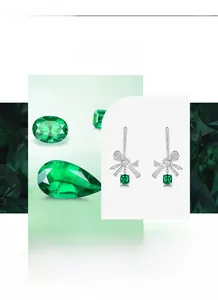 Macro detail of silver bow earrings with emerald green gemstone and cubic zirconia