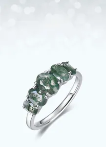 Close-up of five oval green moss agate stones set in a minimalist silver band