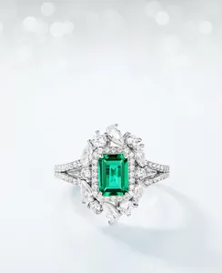 Detailed close-up of an emerald-cut lab-grown emerald ring with white zircon halo
