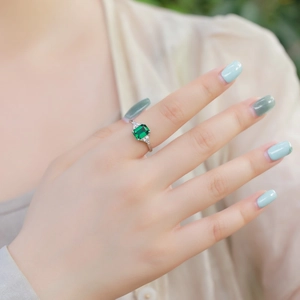 Eleganter S925-Silberring mit grünem Smaragdschliff-Edelstein an einem Fingermodel