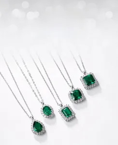 Macro detail of various lab-grown emerald pendant shapes with sparkling silver halo setting