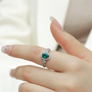 Bague élégante en argent S925 avec émeraude ovale et entourage de diamants sur main