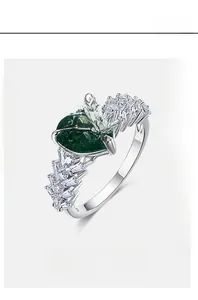 Macro view of heart-cut emerald ring with baguette diamond accents in S925 silver