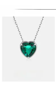 Macro detail of heart-cut lab-grown emerald necklace with silver claw setting