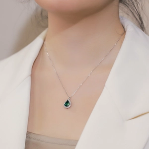 Elegant teardrop emerald pendant necklace with halo crystals on silver chain for women