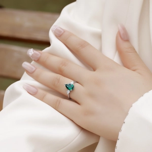 Elegant pear-cut emerald ring in S925 silver setting worn on model's hand