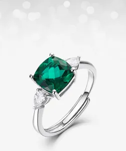 Vue détaillée d'une bague émeraude verte avec zircons blancs en forme de poire sur les côtés