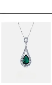 Macro shot of S925 silver pear-cut emerald pendant with halo zircon setting