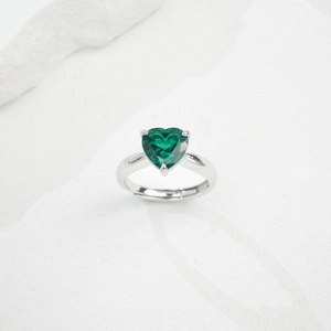 Detailed view of emerald green heart-shaped gemstone ring with adjustable silver band