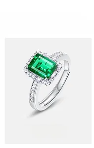 Macro shot of silver ring featuring teardrop emerald gemstone and pavé diamond halo