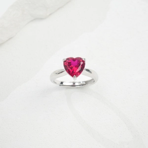 Macro shot of adjustable heart-cut red gemstone ring in silver claw setting