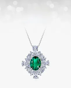 Detailed close-up of emerald pendant necklace with radiant zircon halo and silver chain