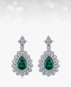 Detail of pear-cut lab emerald earrings with sparkling pavé cubic zirconia accents
