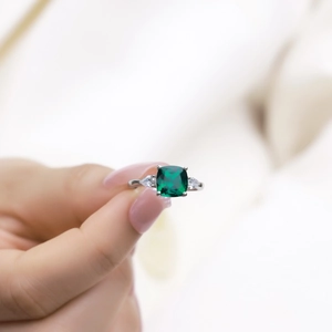Bague en argent S925 avec émeraude carrée et trois pierres portée par un mannequin