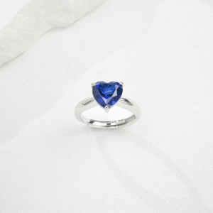 Macro view of adjustable S925 silver ring featuring a heart-shaped emerald-cut green stone