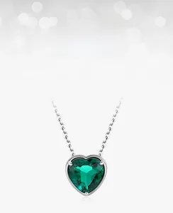 Detail of heart-shaped lab-grown emerald pendant in S925 silver with zircon accents