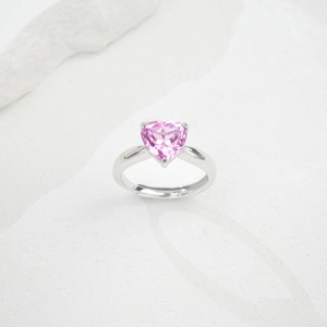 Close-up of heart-shaped pink gemstone set in a silver adjustable open ring band