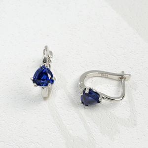 Détail de boucles d'oreilles en argent S925 avec saphir bleu et poinçon gravé