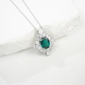 Macro detail of S925 silver necklace with oval emerald gemstone and sparkling white crystals