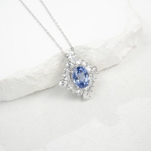 Macro view of S925 silver necklace featuring a large oval blue gemstone and zircon cluster