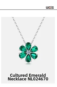 Macro shot of silver necklace with flower-shaped green emerald pendant item NL024670