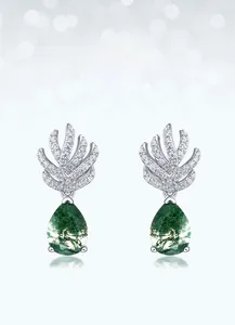 Close-up of pear-shaped moss agate earrings with silver leaf design and zircon pavé