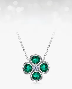 Macro shot of silver four-leaf clover necklace with lab-grown emerald stones and white zircon