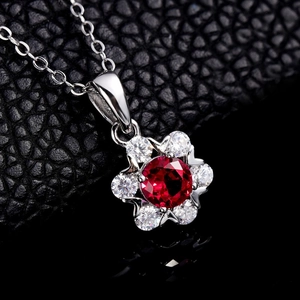 Floral S925 silver necklace with red gemstone pendant on elegant black leather background