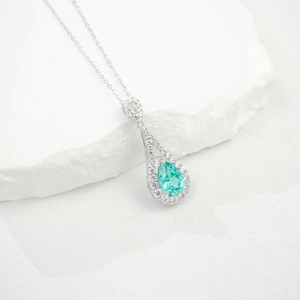 Détail macro d'un pendentif émeraude poire avec pavé de zircons en argent S925