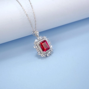 Macro shot of halo pendant with emerald-cut red ruby and brilliant white cubic zirconia
