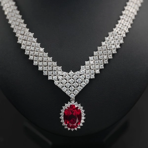 Macro detail of luxury oval ruby pendant necklace with diamond halo on silver chain
