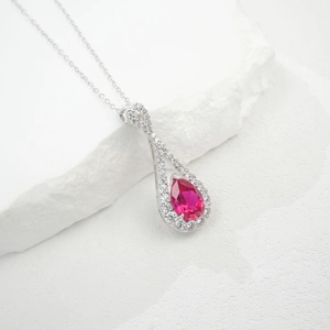 Vue macro du pendentif goutte en argent S925 avec pierre rouge et halo de zircons