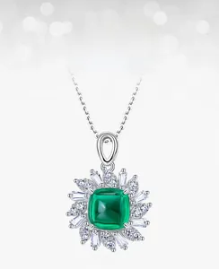 Macro detail of emerald pendant with sunflower design and marquise cut cubic zirconia