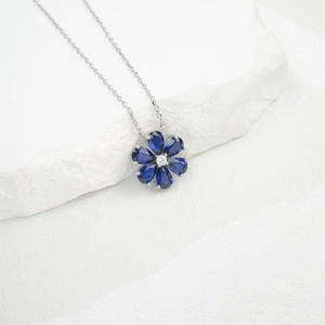 Detail of flower necklace with six pear-cut blue stones and a central white gem