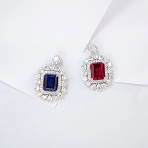 Macro detail of luxury S925 silver pendant with emerald-cut ruby and pear-shaped halo