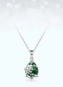 Close-up of teardrop moss agate pendant with silver dragonfly detail and fine chain