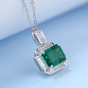 Collier émeraude taille émeraude avec halo de diamants en argent S925 sur fond bleu