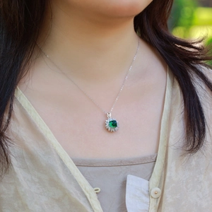 Elegant S925 emerald halo necklace featuring a vibrant green gemstone with floral diamond halo