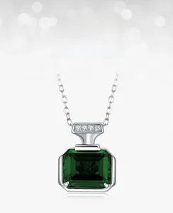Close-up of emerald-cut green gemstone necklace with white zircons on silver chain