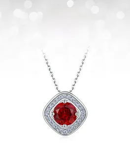 Close-up of lab-grown ruby necklace with halo set stones and fine silver cross chain