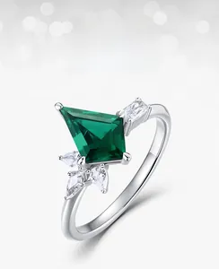 Close-up of lab-grown emerald ring with kite-cut stone and side zircon accents