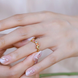 Vue détaillée d'une bague arc-en-ciel en or sertie de pierres précieuses sur un doigt