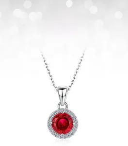 Gros plan du pendentif rubis de laboratoire rond avec chaîne argentée et halo scintillant