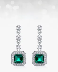 Macro shot of lab-grown emerald earrings featuring square-cut gems and halo setting