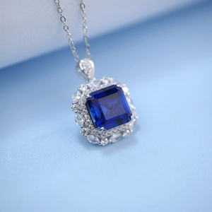 Vue macro du pendentif en argent avec pierre bleue taille émeraude et serti de diamants