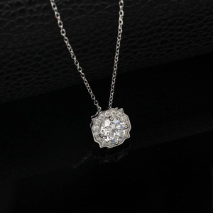 Detail of round lab-grown diamond pendant with octagonal halo on a mirrored surface