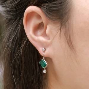 Close-up of S925 silver emerald cut earring with vertical triple stone design on model