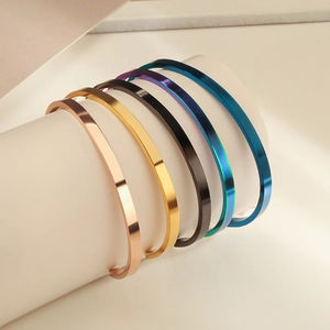 Bracelets joncs en acier inoxydable polis en cinq couleurs sur un support blanc