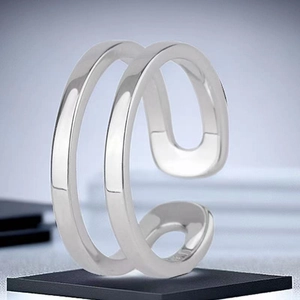 Detail of a minimalist silver double-layer open ring on a black display stand